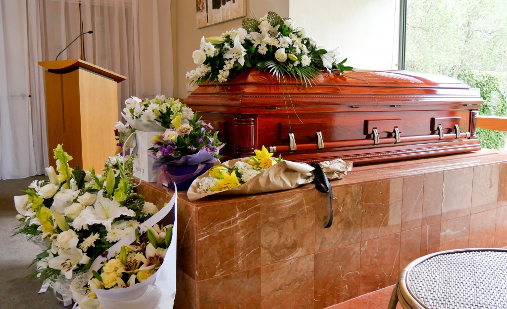 Casket surrounded with different types of flowers