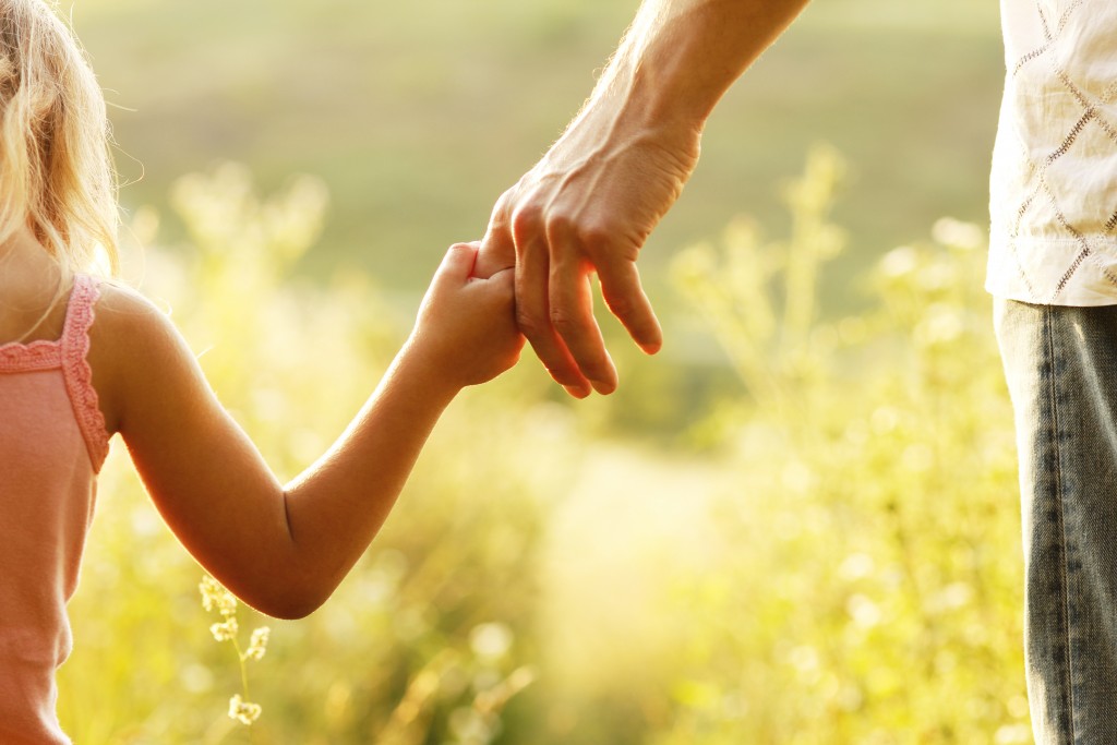 Little girl holding her dad's finger