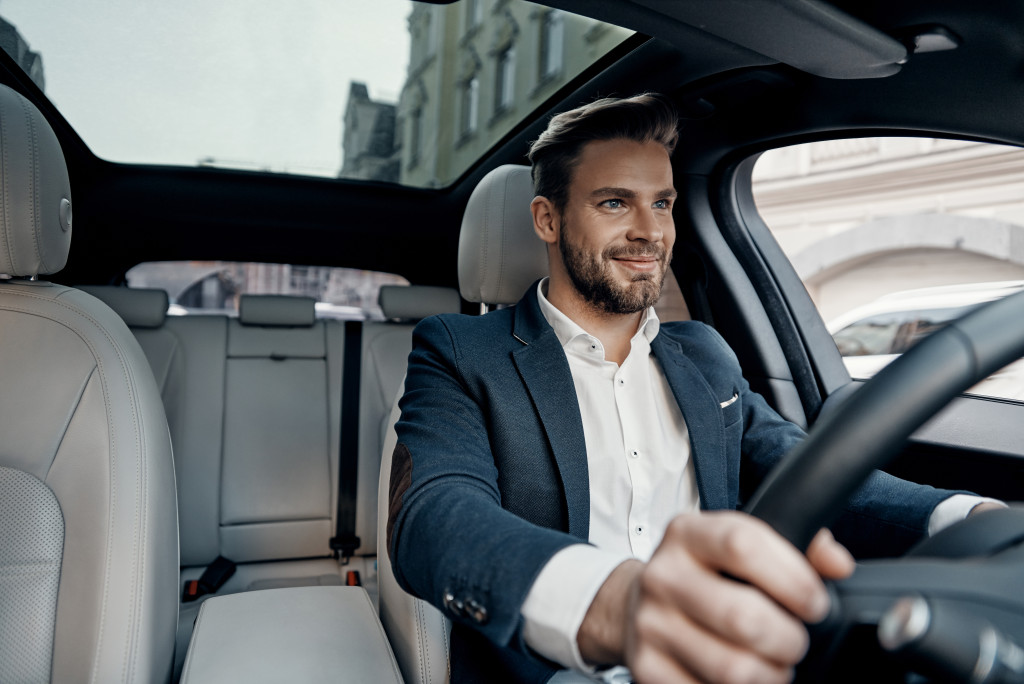 man happily driving his business car