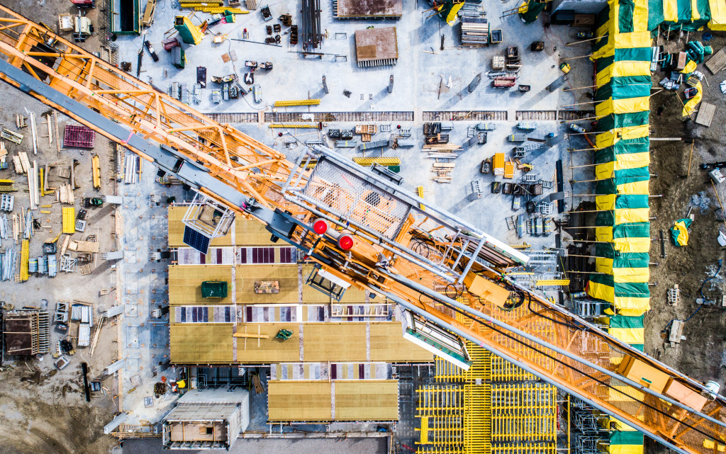 overview of a construction business site with cranes and workers
